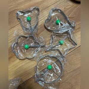 Set of 5 stainless steel Egg & Pancake Molds with Green Handles.